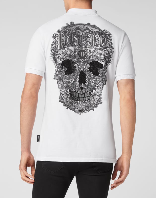 Entdecken Sie die Originalität dieses kurzärmeligen Poloshirts aus Baumwollpiqué, das mit dem ikonischen Totenkopf verziert ist.   Baumwoll-Piqué   Der ikonische barocke, strassbesetzte Skull-Print auf dem Rücken   PP-Sechseck auf einem aufgenähten Aufnäher aus Saffianleder auf der linken Brust   Knöpfe mit Logo   Kragen und Manschetten im Chevron-Rippstrick   Zwei Seitenschlitze