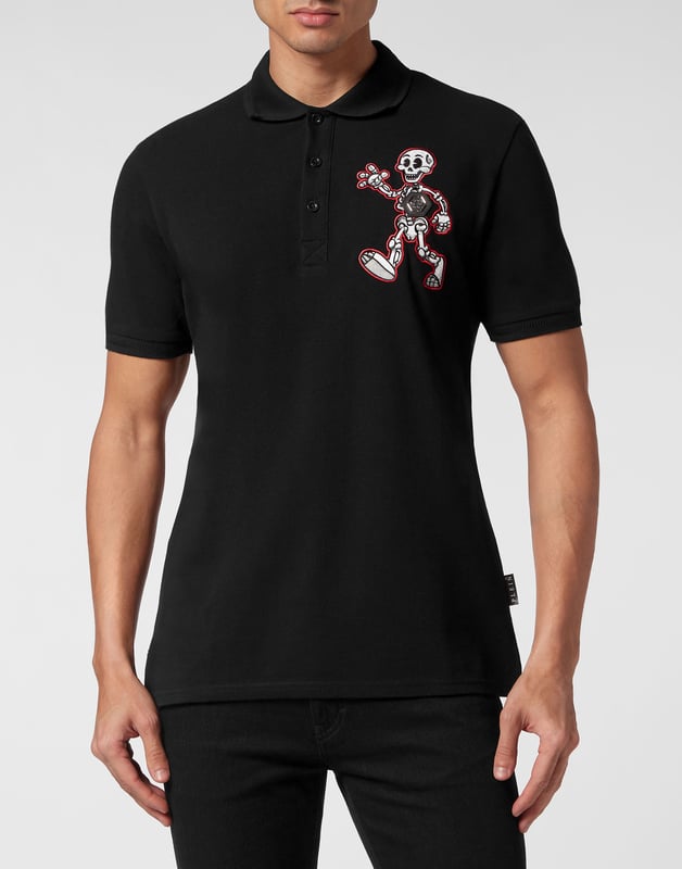 Ontdek de originaliteit van deze polo met korte mouwen, gemaakt van katoen piqué en versierd met origineel borduurwerk.   Katoen piqué   PP Hexagon op een saffiaan lederen patch genaaid op de linkerborst samen met een geborduurde patch van Skeleton, de nieuwe mascotte van dit seizoen   Gothic-stijl Merkopdruk en geborduurd op de rug   Knopen met logo   Chevron ribgebreide kraag en manchetten   Twee zijsplitten