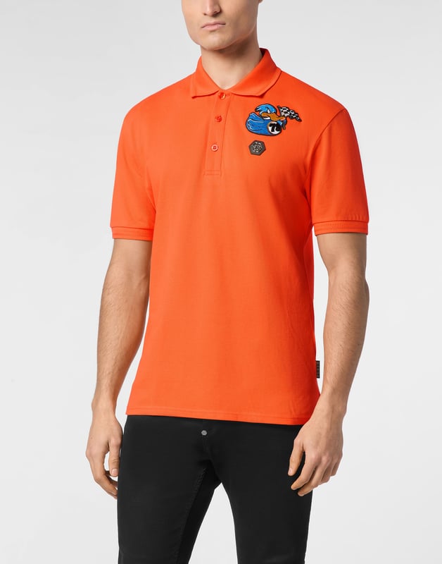 Discover the originality of this cotton piqué short sleeve polo shirt decorated with the Brand’s iconic elements.   Cotton piqué   Embroidered patch   Logoed patch sewn at left chest   Logoed buttons   Rib knit collar and cuffs    Two side slits
