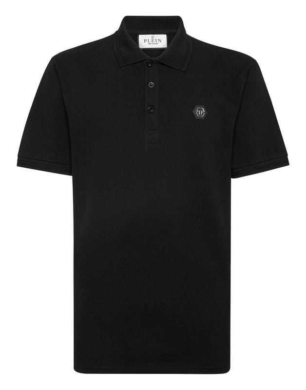 Un clásico imprescindible: el polo de manga corta en piqué de algodón.   Piqué de algodón   El icónico estampado Lettering de estilo gótico en la espalda   Hexágono de PP en un parche de cuero saffian cosido en el lado izquierdo del pecho   Botones con logotipo   Cuello y puños de punto acanalado Chevron   Dos aberturas laterales