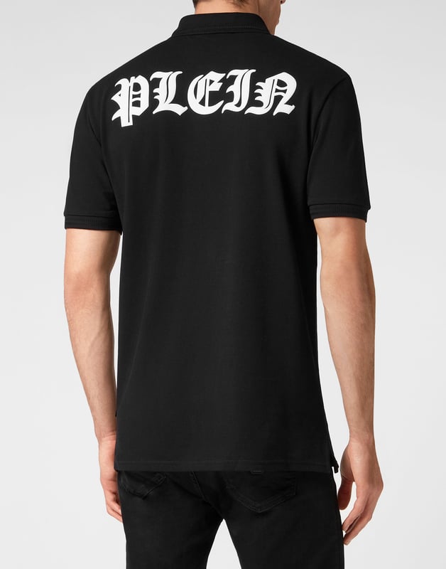 Un clásico imprescindible: el polo de manga corta en piqué de algodón.   Piqué de algodón   El icónico estampado Lettering de estilo gótico en la espalda   Hexágono de PP en un parche de cuero saffian cosido en el lado izquierdo del pecho   Botones con logotipo   Cuello y puños de punto acanalado Chevron   Dos aberturas laterales
