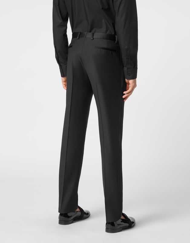 Estos pantalones de esmoquin aportan una precisión moderna a un básico formal atemporal, ofreciendo una silueta entallada impregnada de lujo discreto.   La mezcla de lana virgen garantiza una textura y estructura refinadas.   El corte entallado realza una silueta limpia y alargada.   Las sutiles inserciones de satén evocan la elegancia clásica del esmoquin.   Versátil para combinar con blazers o prendas de punto elevadas.   Ideal para eventos formales o ambientes nocturnos de lujo.