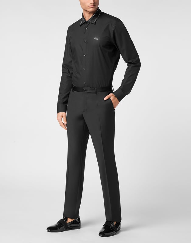 Estos pantalones de esmoquin aportan una precisión moderna a un básico formal atemporal, ofreciendo una silueta entallada impregnada de lujo discreto.   La mezcla de lana virgen garantiza una textura y estructura refinadas.   El corte entallado realza una silueta limpia y alargada.   Las sutiles inserciones de satén evocan la elegancia clásica del esmoquin.   Versátil para combinar con blazers o prendas de punto elevadas.   Ideal para eventos formales o ambientes nocturnos de lujo.
