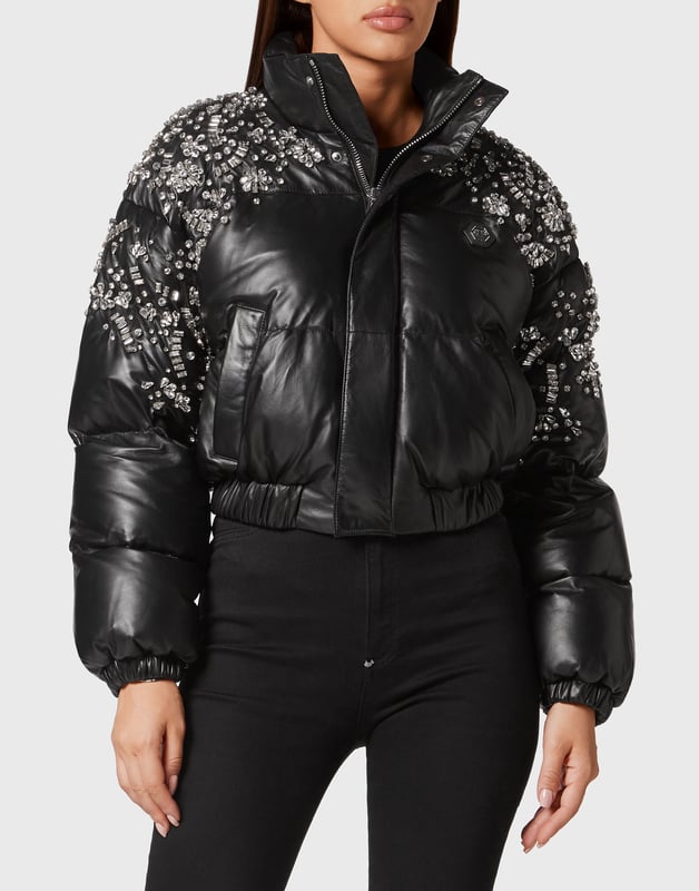 con cristales  La ropa de abrigo se une a la opulencia en este puffer de piel con adornos de cristal: confeccionado para deslumbrar en el frío, es la capa definitiva para un estilo invernal de lujo.    Confeccionado en flexible piel de cordero para una textura rica y pulida.   Los detalles de cristal añaden un glamour y un brillo de alto impacto   El relleno de plumón de ganso garantiza calidez y volumen ligeros   La silueta recortada equilibra la audacia con la feminidad   Una fusión espectacular de funcionalidad y estilo lujoso