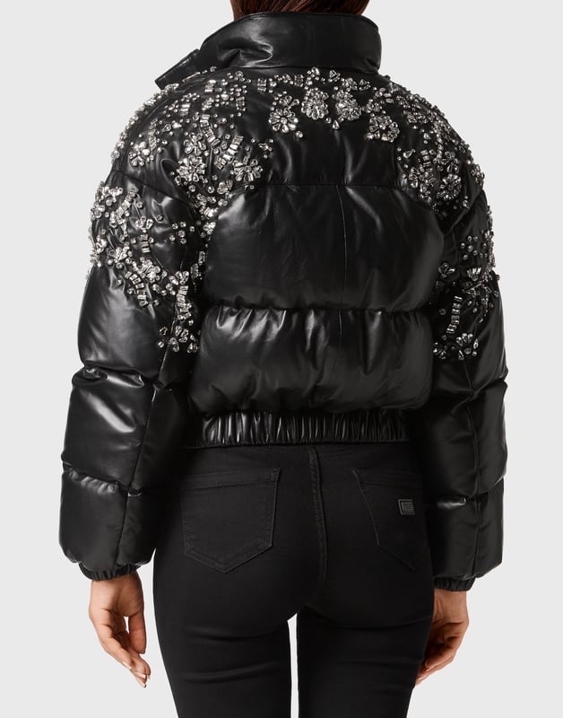 con cristales  La ropa de abrigo se une a la opulencia en este puffer de piel con adornos de cristal: confeccionado para deslumbrar en el frío, es la capa definitiva para un estilo invernal de lujo.    Confeccionado en flexible piel de cordero para una textura rica y pulida.   Los detalles de cristal añaden un glamour y un brillo de alto impacto   El relleno de plumón de ganso garantiza calidez y volumen ligeros   La silueta recortada equilibra la audacia con la feminidad   Una fusión espectacular de funcionalidad y estilo lujoso