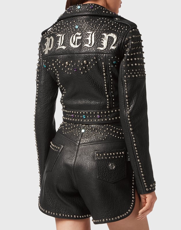 Lederjacke mit Nietenverzierungen Befreie deinen Rockgeist und entdecke neue Looks mit dem Leder-Perfecto, den wir für diese Saison entworfen haben. Sehen Sie sich die Details an. Weiches Leder mit Vintage-Effekt Gothic Plein aus Metall auf der Rückseite Metallnieten und farbige Strasssteine Druckknopfriemen Metallreißverschluss auf der Vorderseite, an den Manschetten und den Taschen Futter aus rautenförmig gestepptem, getupftem Stoff