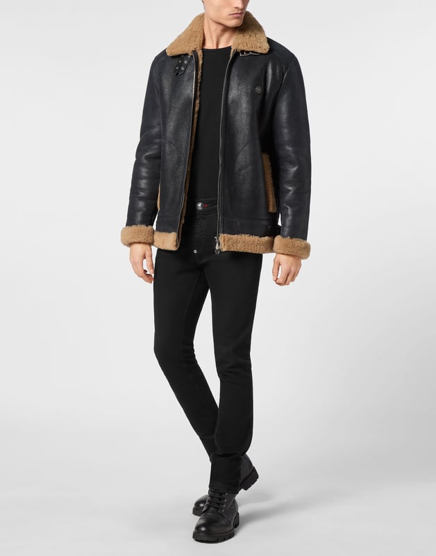 Discover the style of Plein with this sheepskin jacket. Check out its distinctive details.   Sheepskin with fur trim finish   Schafsfell shirt collar with two leather straps   Schafsfell Skull&Bones on the back   PP Hexagon Logo on a saffian leather patch sewn at left chest   Zip fastener   Two slit pockets with stitched outline   Two side straps on bottom hem   Unlined