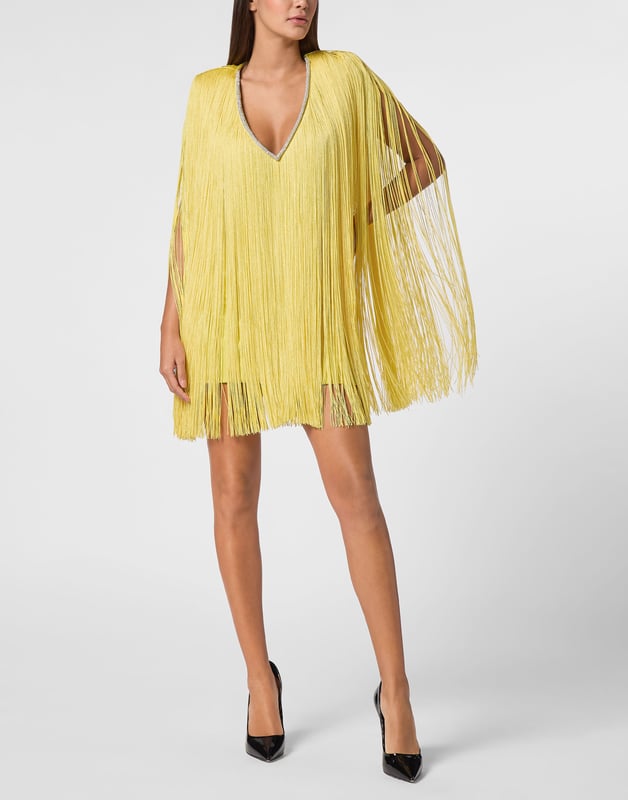 Als je van glamour houdt, raden we je deze unieke en originele avondjurk aan. Ontdek de verzorgende details.   Jersey met rayon kwastjes   V-hals met sierrand   Ritssluiting opzij   Gewatteerde schouders