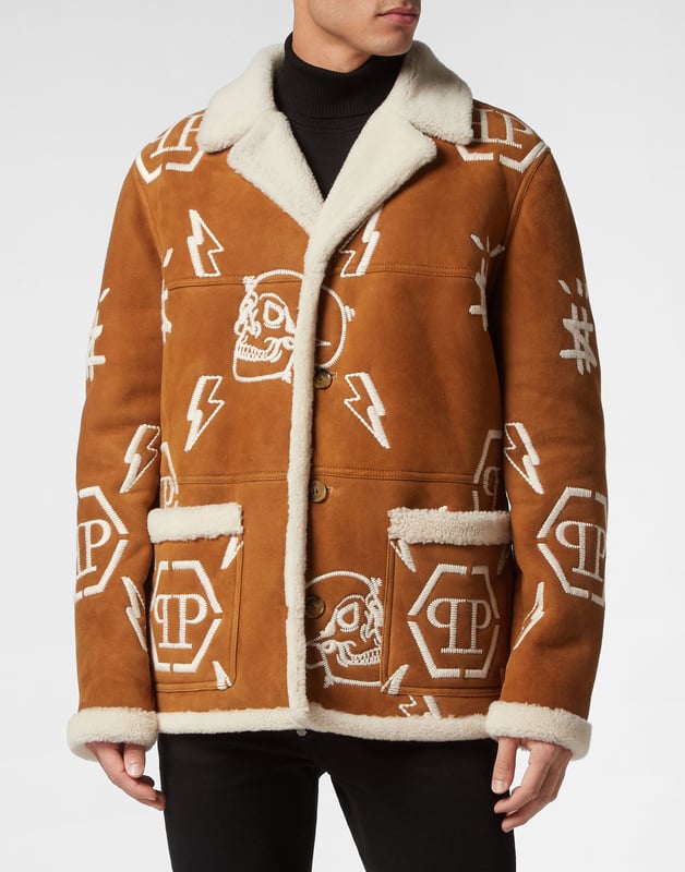 Mantel Monogram Entdecken Sie den Stil von Plein mit diesem Mantel aus Schafsleder. Sehen Sie sich die besonderen Details an. Schafsfell mit Pelzbesatz Reverskragen aus Shearling Durchgehend gestickte Markenelemente PP-Sechseck auf einem auf die Passe aufgenähten Saffianleder-Patch Hornknöpfe Zwei aufgesetzte Taschen Ungefüttert