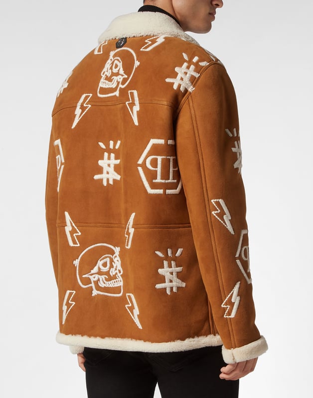 Mantel Monogram Entdecken Sie den Stil von Plein mit diesem Mantel aus Schafsleder. Sehen Sie sich die besonderen Details an. Schafsfell mit Pelzbesatz Reverskragen aus Shearling Durchgehend gestickte Markenelemente PP-Sechseck auf einem auf die Passe aufgenähten Saffianleder-Patch Hornknöpfe Zwei aufgesetzte Taschen Ungefüttert