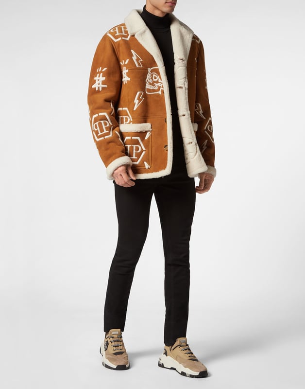 Mantel Monogram Entdecken Sie den Stil von Plein mit diesem Mantel aus Schafsleder. Sehen Sie sich die besonderen Details an. Schafsfell mit Pelzbesatz Reverskragen aus Shearling Durchgehend gestickte Markenelemente PP-Sechseck auf einem auf die Passe aufgenähten Saffianleder-Patch Hornknöpfe Zwei aufgesetzte Taschen Ungefüttert