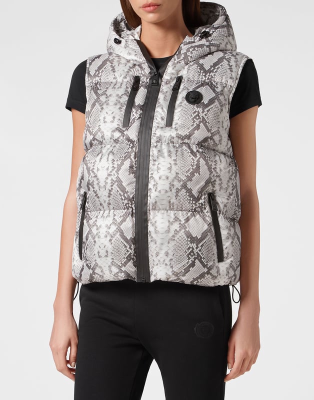 Echa un vistazo a esta chaqueta sin mangas con capucha, acolchada y aislante, adecuada para después del entrenamiento. Cálida, ligera y con una protección óptima.   Estampado de pitón, nylon y acolchado.    Estampado de la marca en la espalda   La capucha se puede plegar para formar un cuello alto protector   Cierre de cremallera impermeable en la parte delantera y los bolsillos    Parche de silicona 3D cosido en el pecho izquierdo   Dobladillo inferior elástico   Forro interior   Aislamiento sintético