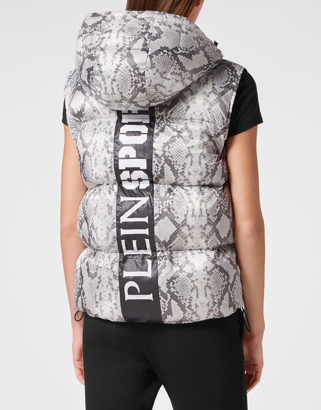 Echa un vistazo a esta chaqueta sin mangas con capucha, acolchada y aislante, adecuada para después del entrenamiento. Cálida, ligera y con una protección óptima.   Estampado de pitón, nylon y acolchado.    Estampado de la marca en la espalda   La capucha se puede plegar para formar un cuello alto protector   Cierre de cremallera impermeable en la parte delantera y los bolsillos    Parche de silicona 3D cosido en el pecho izquierdo   Dobladillo inferior elástico   Forro interior   Aislamiento sintético