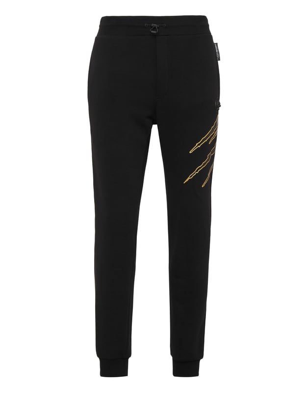 Estos pantalones de jogging diseñados para cualquier entrenamiento, son el complemento perfecto para alcanzar tus objetivos. Comodidad y rendimiento se suman al estilo de Plein Sport.   Forro polar de algodón   Patrón estampado en la parte delantera y trasera   Cintura de punto elástico con cordón   Parche cosido en la pernera izquierda   Dos bolsillos con aberturas   Puños inferiores de punto elástico.