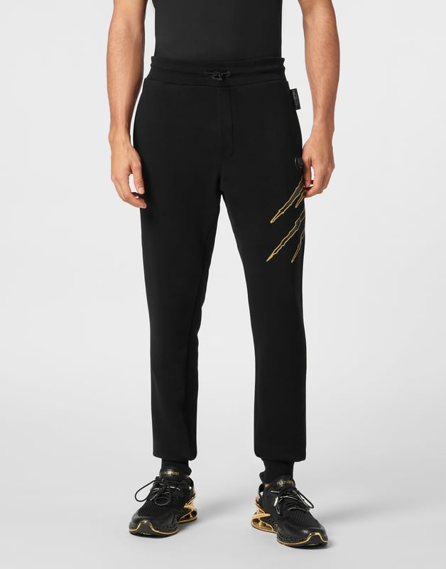 Estos pantalones de jogging diseñados para cualquier entrenamiento, son el complemento perfecto para alcanzar tus objetivos. Comodidad y rendimiento se suman al estilo de Plein Sport.   Forro polar de algodón   Patrón estampado en la parte delantera y trasera   Cintura de punto elástico con cordón   Parche cosido en la pernera izquierda   Dos bolsillos con aberturas   Puños inferiores de punto elástico.