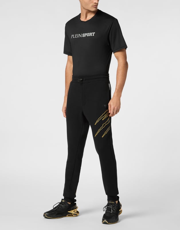 Estos pantalones de jogging diseñados para cualquier entrenamiento, son el complemento perfecto para alcanzar tus objetivos. Comodidad y rendimiento se suman al estilo de Plein Sport.   Forro polar de algodón   Patrón estampado en la parte delantera y trasera   Cintura de punto elástico con cordón   Parche cosido en la pernera izquierda   Dos bolsillos con aberturas   Puños inferiores de punto elástico.