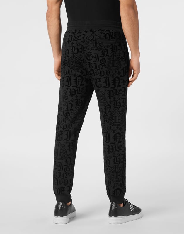 Entdecken Sie die Originalität dieser Jogginghose mit Jacquard-Muster.   Baumwollmischgewebe mit allover beflocktem Muster   Aufnäher mit Logo   Schlitztaschen   Gerippter Bund mit Stopp-Kordelzug   Rippstrickbündchen