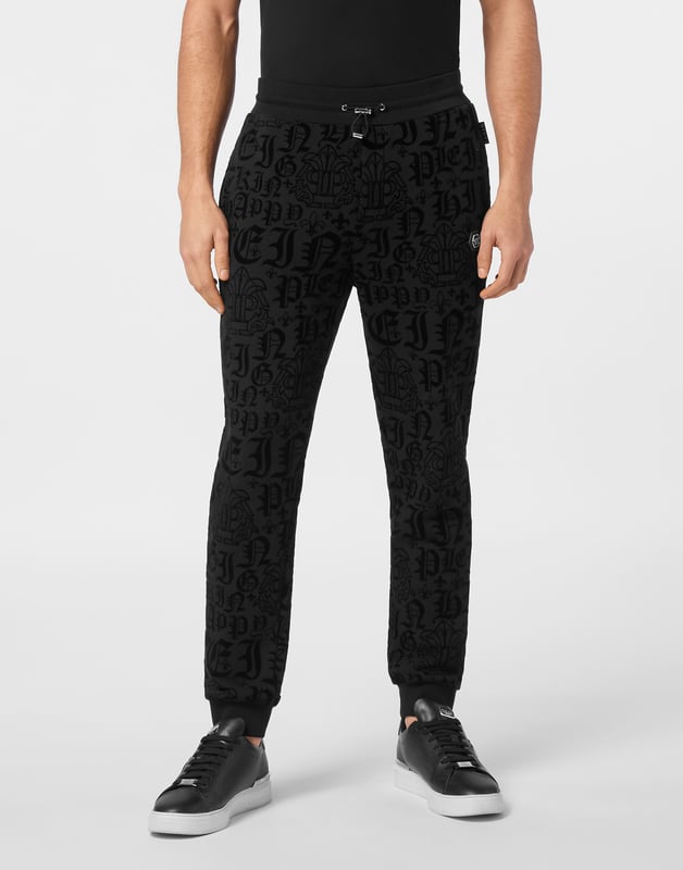 Entdecken Sie die Originalität dieser Jogginghose mit Jacquard-Muster.   Baumwollmischgewebe mit allover beflocktem Muster   Aufnäher mit Logo   Schlitztaschen   Gerippter Bund mit Stopp-Kordelzug   Rippstrickbündchen
