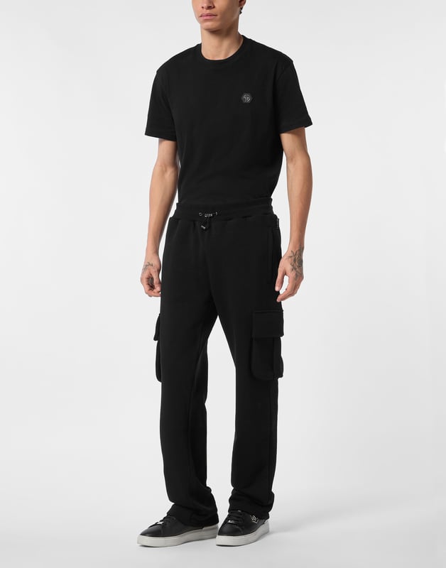 Entdecken Sie die Originalität dieser Jogginghose aus Baumwollfleece, die mit einzigartigen Details verziert ist.   Baumwollfleece-Mischung   Aufnäher mit Logo   Zwei Zwickeltaschen mit Patten   Schlitztaschen   Gerippter Bund mit Stopp-Kordelzug