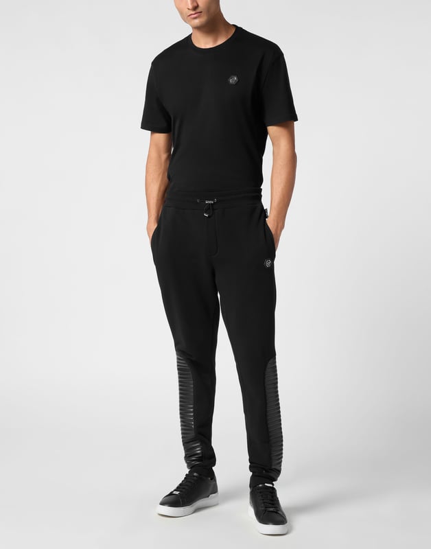 Entdecken Sie die Einzigartigkeit dieser Jogginghose aus Baumwollfleece mit speziellen Nähten.   Baumwollmischung aus Fleece   Gesteppte Kunstlederelemente   Aufnäher mit Logo   Zwei Eingrifftaschen   Gerippter Bund mit Stopp-Kordelzug   Rippstrickbündchen unten
