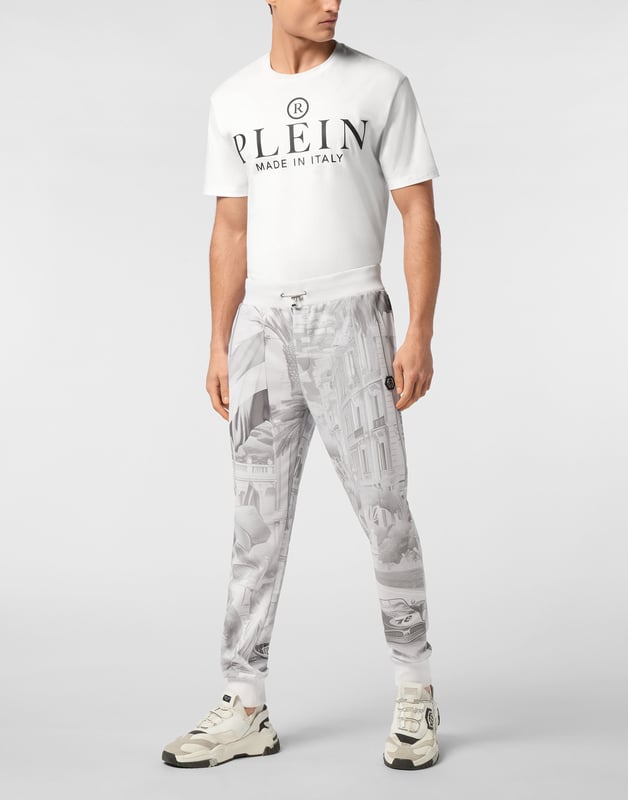 Descubra la originalidad de estos pantalones de chándal de forro polar de mezcla de algodón decorados con detalles únicos.   Forro polar de mezcla de algodón suave estampado por toda la prenda.   Bordado en la parte trasera   Parche con logotipo   Bolsillos con aberturas   Cintura de canalé con cordón de ajuste de tope   Puños de punto elástico