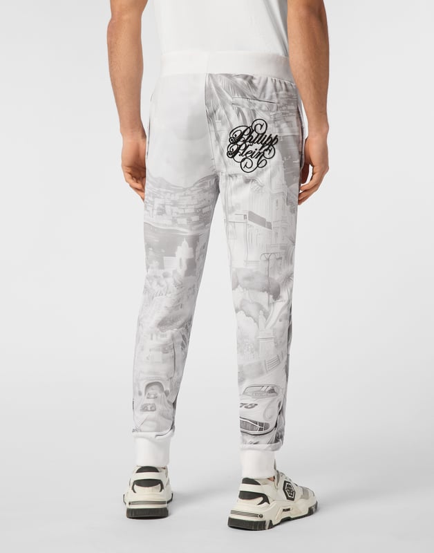 Descubra la originalidad de estos pantalones de chándal de forro polar de mezcla de algodón decorados con detalles únicos.   Forro polar de mezcla de algodón suave estampado por toda la prenda.   Bordado en la parte trasera   Parche con logotipo   Bolsillos con aberturas   Cintura de canalé con cordón de ajuste de tope   Puños de punto elástico