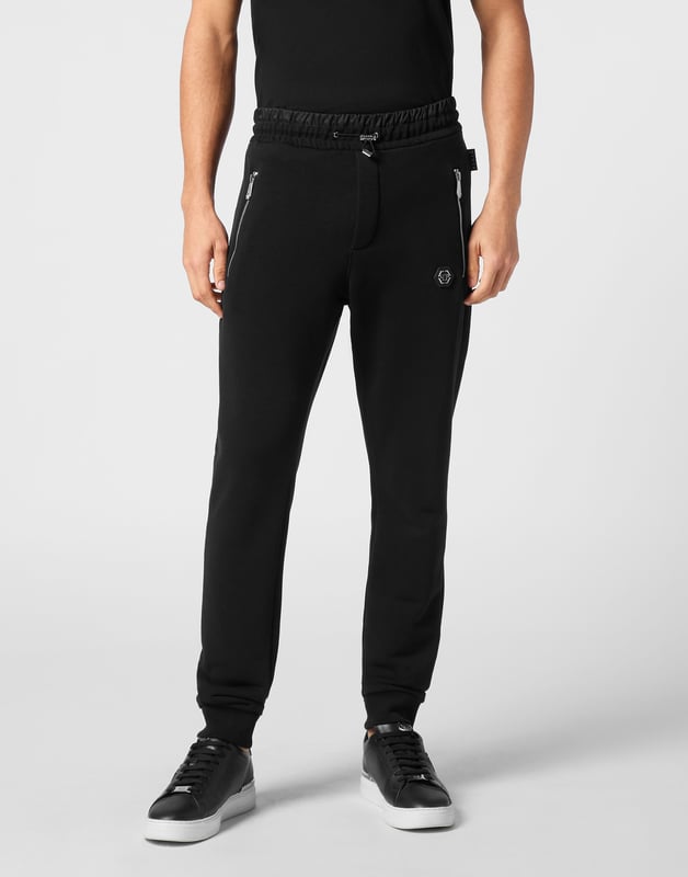 Entdecken Sie die Einzigartigkeit dieser Jogginghose aus Baumwollfleece mit speziellen Nähten.   Fleece aus Baumwollmischung   Aufnäher mit Logo   Reißverschlusstaschen   Eine Gesäßtasche   Gerippter Bund mit Stopp-Kordelzug   Rippstrickbündchen unten