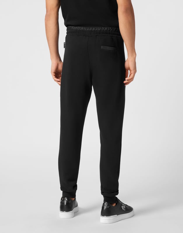 Entdecken Sie die Einzigartigkeit dieser Jogginghose aus Baumwollfleece mit speziellen Nähten.   Fleece aus Baumwollmischung   Aufnäher mit Logo   Reißverschlusstaschen   Eine Gesäßtasche   Gerippter Bund mit Stopp-Kordelzug   Rippstrickbündchen unten