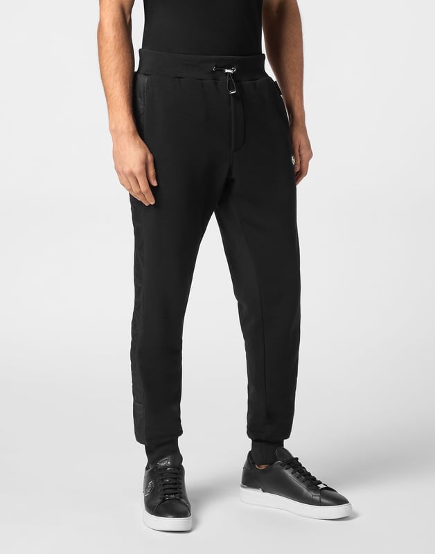 Entdecken Sie die Originalität dieser Jogginghose aus Baumwollfleece, die mit einzigartigen Nähten verziert ist.   Baumwoll-Fleece-Mischung   Gepolsterte Nylondetails   PP Hexagon Logo auf einem Lederabzeichen aus Safran auf dem linken Bein   Schlitztaschen   Gerippter Bund mit Stoppkordelzug   Rippstrickbündchen