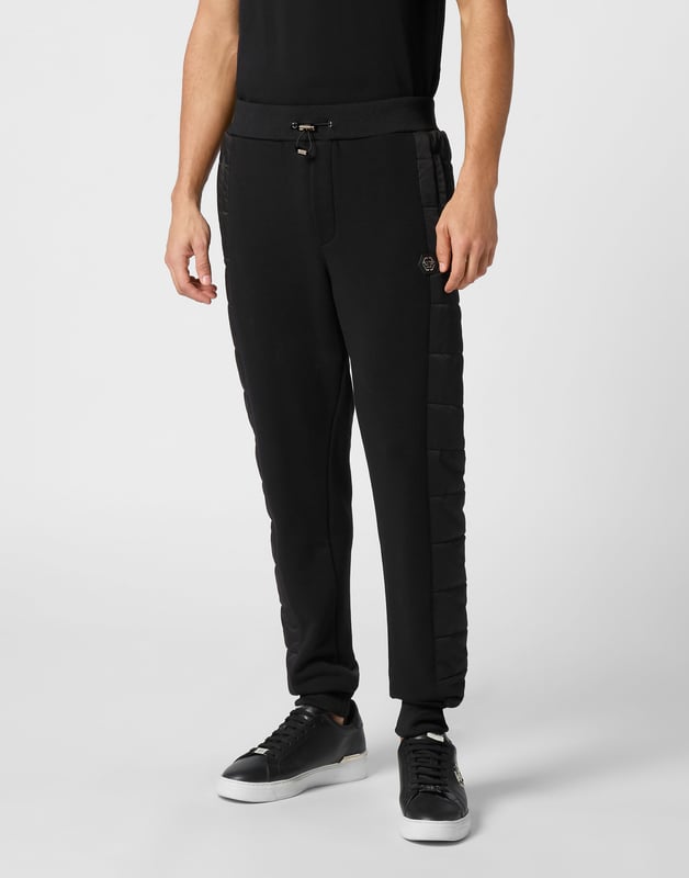 Entdecken Sie die Originalität dieser Jogginghose aus Baumwollmischfleece, die mit einzigartigen Nähten verziert ist.   Baumwollfleece-Mischung   Nylon wattierte Details   Logo-Aufnäher   Eingrifftaschen   Rippenbund mit Stopp-Kordelzug   Rippenstrickbündchen