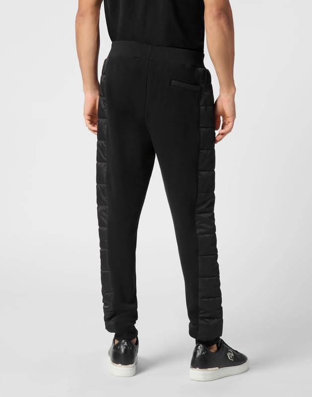 Entdecken Sie die Originalität dieser Jogginghose aus Baumwollmischfleece, die mit einzigartigen Nähten verziert ist.   Baumwollfleece-Mischung   Nylon wattierte Details   Logo-Aufnäher   Eingrifftaschen   Rippenbund mit Stopp-Kordelzug   Rippenstrickbündchen
