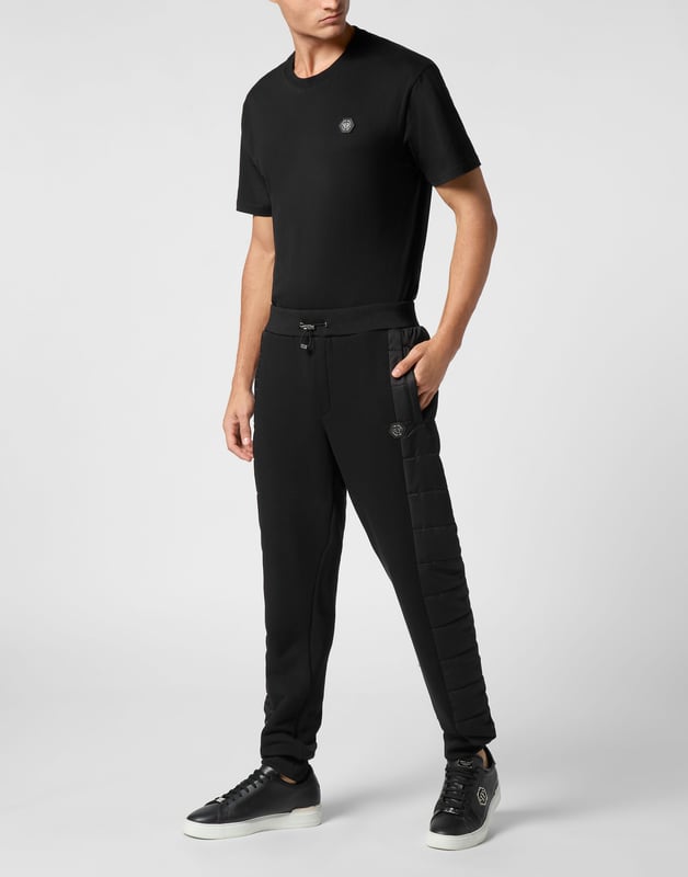 Entdecken Sie die Originalität dieser Jogginghose aus Baumwollmischfleece, die mit einzigartigen Nähten verziert ist.   Baumwollfleece-Mischung   Nylon wattierte Details   Logo-Aufnäher   Eingrifftaschen   Rippenbund mit Stopp-Kordelzug   Rippenstrickbündchen