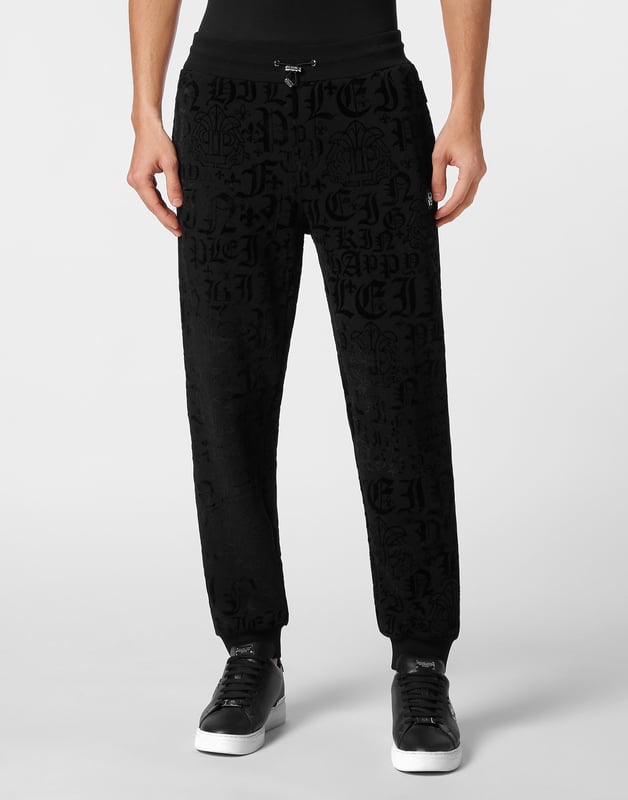 Defina su estilo con un toque de personalidad. Luzca este pantalón jogging de forro polar de algodón con un original estampado.    Suave forro polar de mezcla de algodón.   Estampado de letras flocadas por toda la prenda    Hexágono de PP en una insignia de cuero saffiano cosida en el lateral izquierdo   Bolsillos con aberturas   Cintura parcialmente de nailon elástico con cordón de tope   Puños de punto elástico