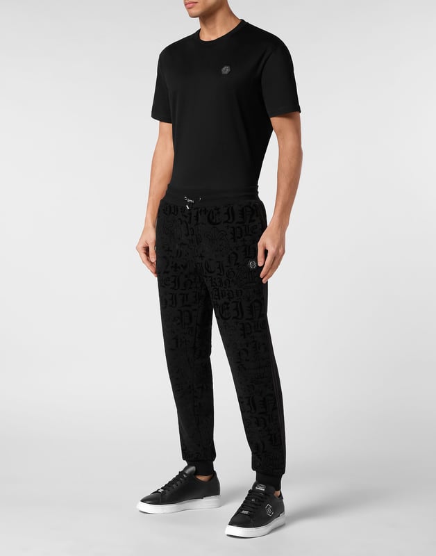 Defina su estilo con un toque de personalidad. Luzca este pantalón jogging de forro polar de algodón con un original estampado.    Suave forro polar de mezcla de algodón.   Estampado de letras flocadas por toda la prenda    Hexágono de PP en una insignia de cuero saffiano cosida en el lateral izquierdo   Bolsillos con aberturas   Cintura parcialmente de nailon elástico con cordón de tope   Puños de punto elástico