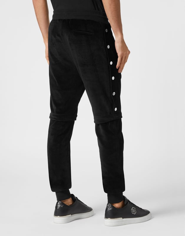 Entscheiden Sie sich für das stilvolle Joggen mit der Einzigartigkeit, die den Stil von Plein ausmacht. Wir haben diese weiche Chenille-Hose entworfen. Sehen Sie sich alle Details an.   Chenille-Samt   Hosenbeine mit Druckknopfverschluss   Nahtdetails   PP-Sechseck auf einem auf der linken Seite aufgenähten Abzeichen aus Saffianleder   Schlitztaschen   Rippenstrick-Bund mit Stopp-Kordelzug   Rippstrickbündchen