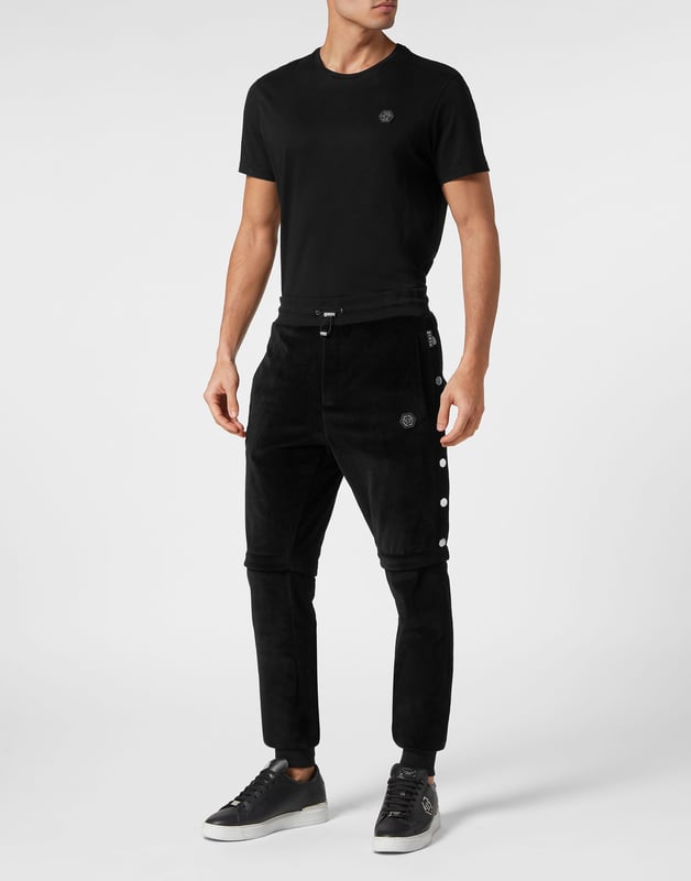 Entscheiden Sie sich für das stilvolle Joggen mit der Einzigartigkeit, die den Stil von Plein ausmacht. Wir haben diese weiche Chenille-Hose entworfen. Sehen Sie sich alle Details an.   Chenille-Samt   Hosenbeine mit Druckknopfverschluss   Nahtdetails   PP-Sechseck auf einem auf der linken Seite aufgenähten Abzeichen aus Saffianleder   Schlitztaschen   Rippenstrick-Bund mit Stopp-Kordelzug   Rippstrickbündchen
