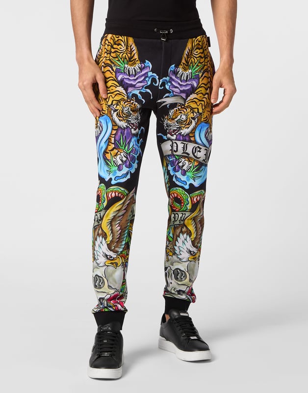 Si lo suyo son los conjuntos deportivos con un toque de personalidad, eche un vistazo a estos pantalones de chándal de forro polar de mezcla de algodón.   Suave forro polar de mezcla de algodón   Decoraciones estampadas con efecto tatuaje    Hexágono de PP en una insignia de cuero saffiano cosida en el lado izquierdo   Bolsillos con aberturas   Cintura parcialmente de nailon elástico con cordón de tope   Puños de punto elástico