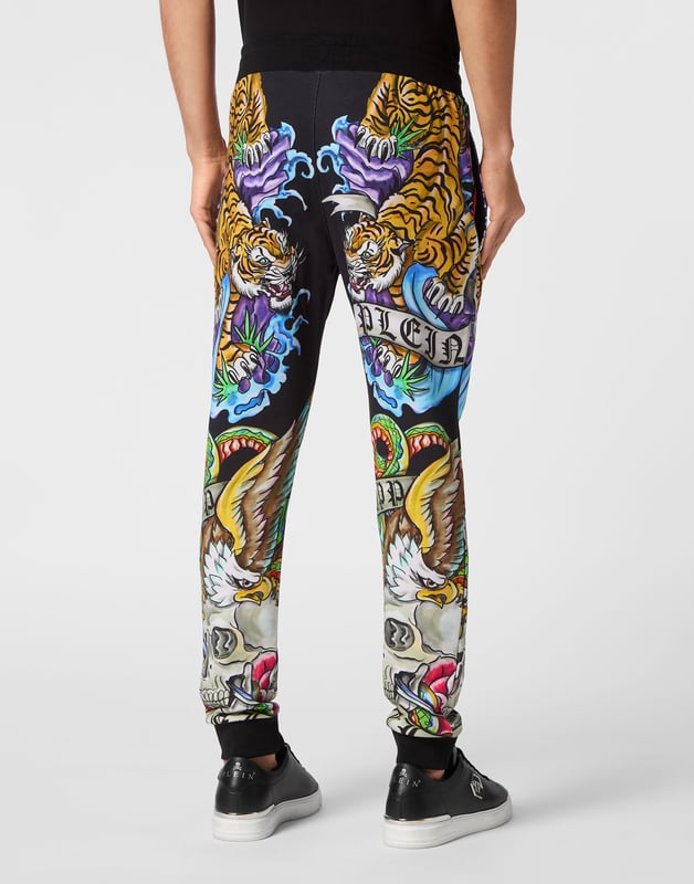 Si lo suyo son los conjuntos deportivos con un toque de personalidad, eche un vistazo a estos pantalones de chándal de forro polar de mezcla de algodón.   Suave forro polar de mezcla de algodón   Decoraciones estampadas con efecto tatuaje    Hexágono de PP en una insignia de cuero saffiano cosida en el lado izquierdo   Bolsillos con aberturas   Cintura parcialmente de nailon elástico con cordón de tope   Puños de punto elástico