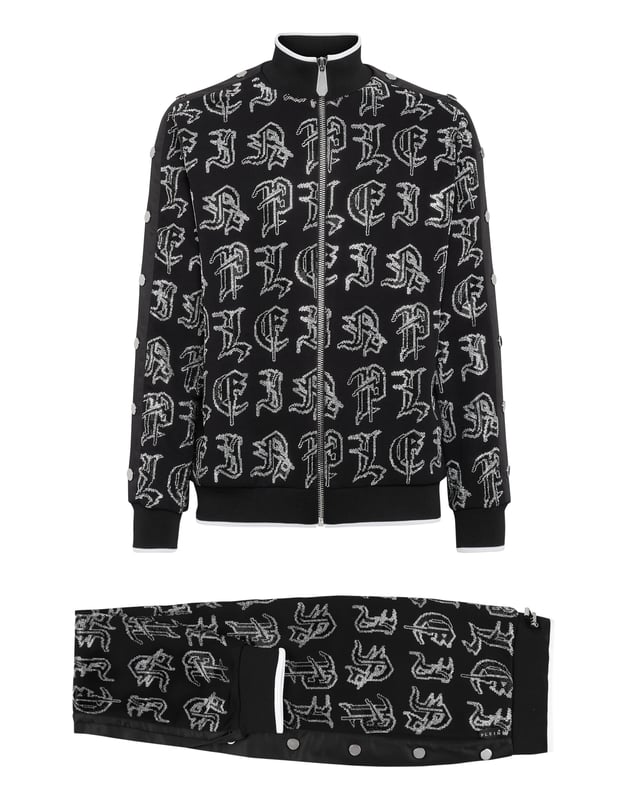 Elija correr con estilo con la singularidad que identifica el estilo de Plein. Hemos diseñado este chándal de forro polar de algodón elástico con pedrería.   Forro polar de algodón con letras de pedrería de estilo gótico.   Pantalón y parte superior con botones laterales de color en contraste    Cierre de cremallera   Bolsillos con aberturas   Cintura con cordón de ajuste de tope   Dobladillos con remates de punto elástico