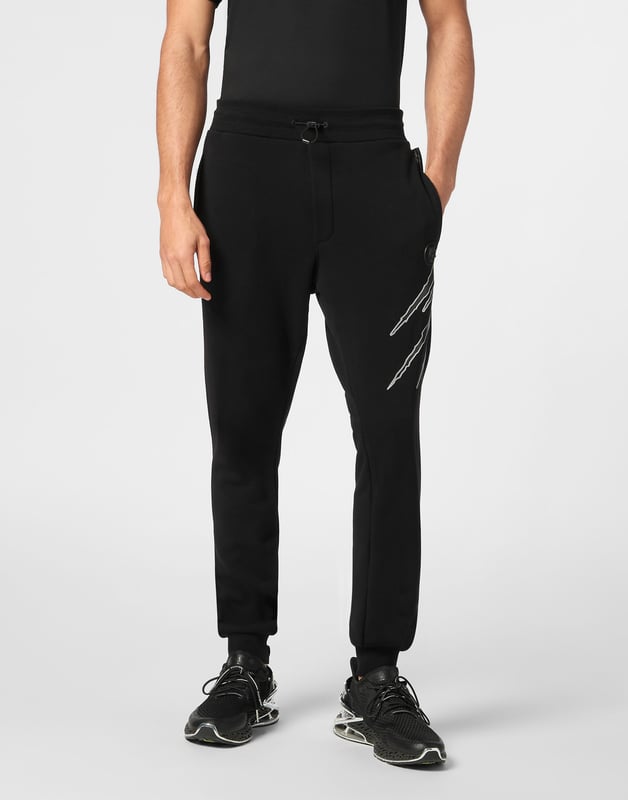Estos pantalones de jogging diseñados para cualquier entrenamiento, son el complemento perfecto para alcanzar tus objetivos. Comodidad y rendimiento se suman al estilo de Plein Sport.   Forro polar de algodón   Patrón estampado en la parte delantera y trasera   Cintura de punto elástico con cordón   Parche cosido en la pernera izquierda   Dos bolsillos con aberturas   Puños inferiores de punto elástico.