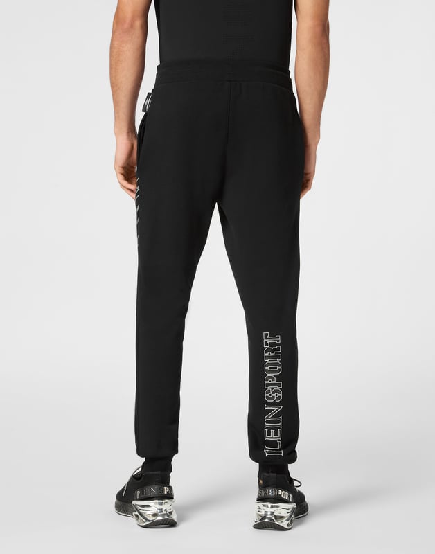 Estos pantalones de jogging diseñados para cualquier entrenamiento, son el complemento perfecto para alcanzar tus objetivos. Comodidad y rendimiento se suman al estilo de Plein Sport.   Forro polar de algodón   Patrón estampado en la parte delantera y trasera   Cintura de punto elástico con cordón   Parche cosido en la pernera izquierda   Dos bolsillos con aberturas   Puños inferiores de punto elástico.