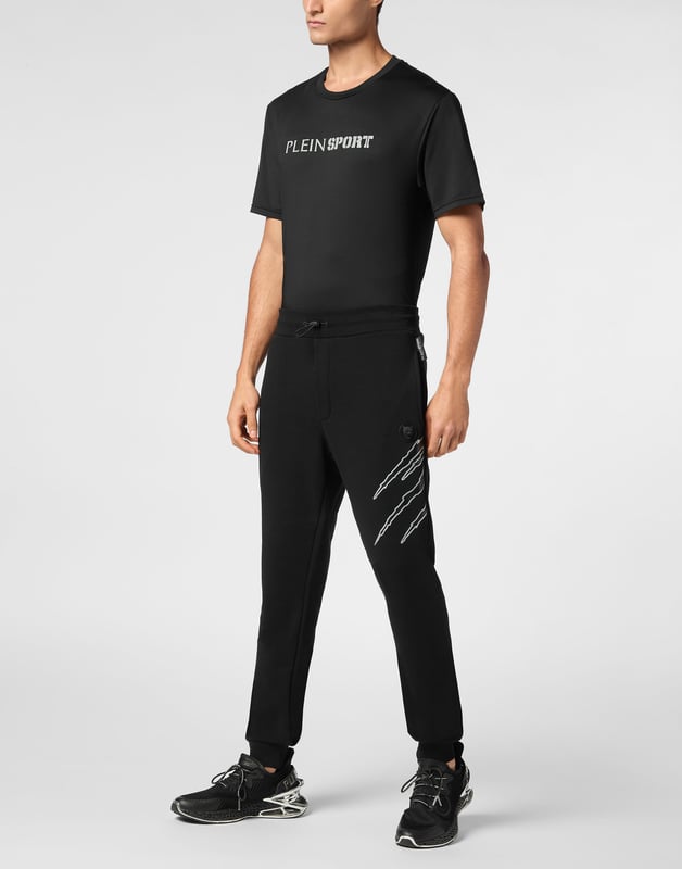 Estos pantalones de jogging diseñados para cualquier entrenamiento, son el complemento perfecto para alcanzar tus objetivos. Comodidad y rendimiento se suman al estilo de Plein Sport.   Forro polar de algodón   Patrón estampado en la parte delantera y trasera   Cintura de punto elástico con cordón   Parche cosido en la pernera izquierda   Dos bolsillos con aberturas   Puños inferiores de punto elástico.