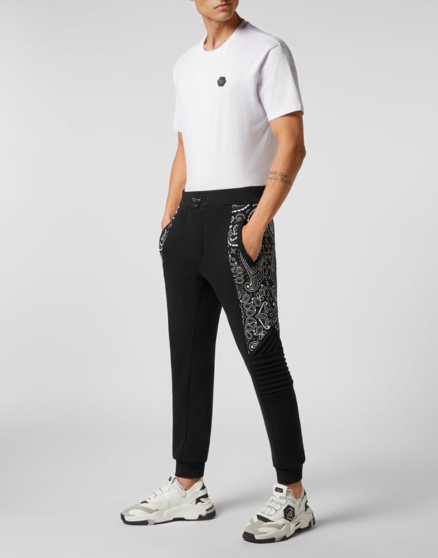 No descuida su tiempo libre. Hemos diseñado estos joggers de forro polar de algodón con motivos Paisley.   Forro polar de algodón suave con estampado Paisley    Hexágono PP en una insignia de cuero saffiano cosida en el lado izquierdo   Bolsillos con aberturas   Cintura con cordón de ajuste   Dobladillos de punto elástico