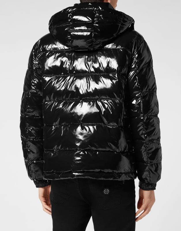 Hochglänzender Daunenbomber aus Nylon mit Kapuze. Das Kleidungsstück ist vollständig gesteppt. Ein Aufnäher aus Saffianleder mit dem PP Hexagon ist auf der linken Brustseite aufgenäht. Reißverschluss und zwei Einschubtaschen mit Reißverschluss. Manschetten mit Druckknöpfen. Kordelzug am unteren Saum. Wattiertes Futter.