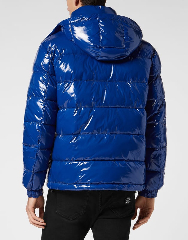 Hochglänzender Daunenbomber aus Nylon mit Kapuze. Das Kleidungsstück ist vollständig gesteppt. Ein Aufnäher aus Saffianleder mit dem PP Hexagon ist auf der linken Brustseite aufgenäht. Reißverschluss und zwei Einschubtaschen mit Reißverschluss. Manschetten mit Druckknöpfen. Kordelzug am unteren Saum. Wattiertes Futter.