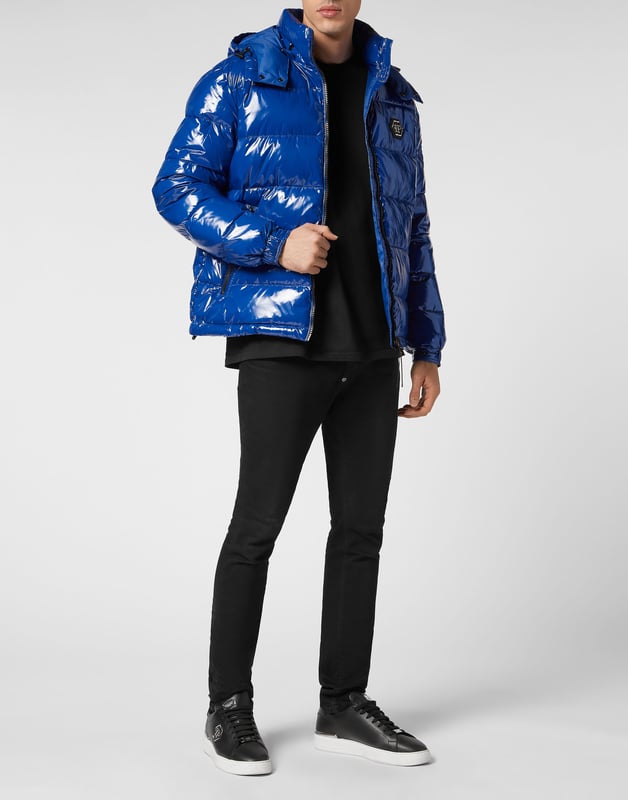 Hochglänzender Daunenbomber aus Nylon mit Kapuze. Das Kleidungsstück ist vollständig gesteppt. Ein Aufnäher aus Saffianleder mit dem PP Hexagon ist auf der linken Brustseite aufgenäht. Reißverschluss und zwei Einschubtaschen mit Reißverschluss. Manschetten mit Druckknöpfen. Kordelzug am unteren Saum. Wattiertes Futter.