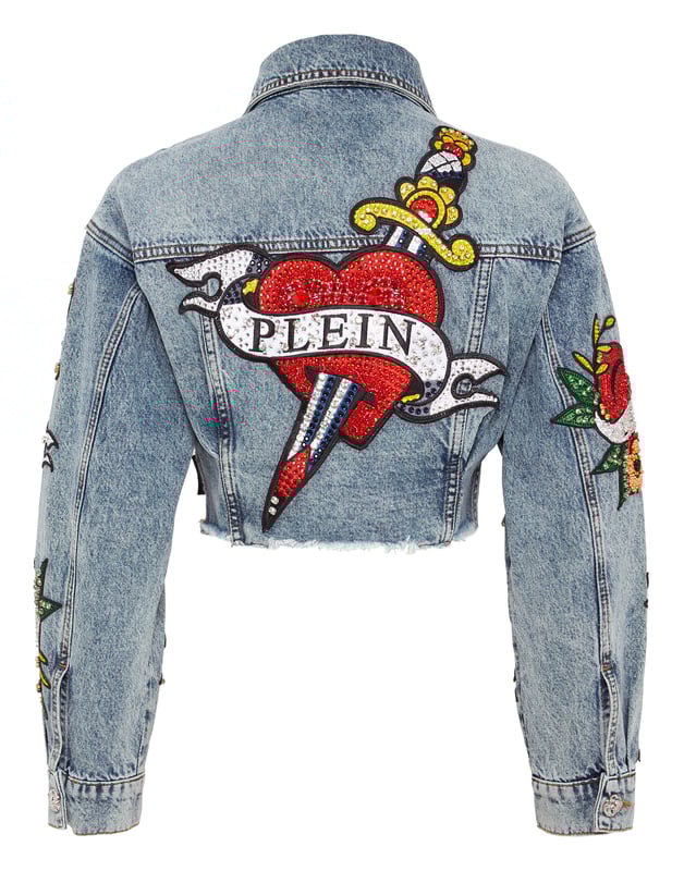 Verfraaid  Draag de stijl van Plein met dit kostbare denim crop jack met de thema-elementen van dit seizoen. Bekijk de kenmerkende details.   Steengewassen denim   Met rijnen versierde patches met Love Tattoo-thema   Metalen juwelenknopen   Twee opgestikte zakken met klep   Ruw gesneden onderboord