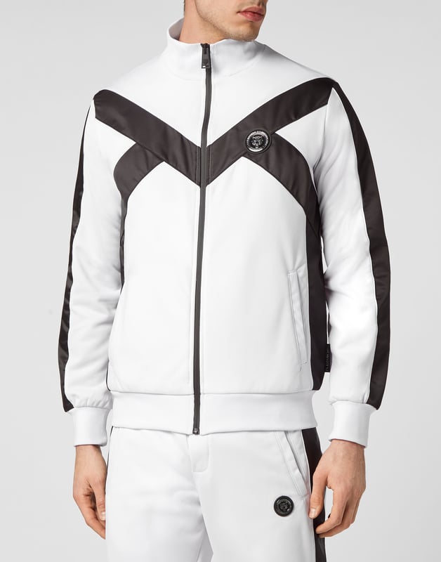 Entdecke den neuen Trainingsanzug, mit dem du beim Sport und in der Freizeit glänzen kannst.   Handliches und widerstandsfähiges Triacetat   Unifarbene Nylon-Einsätze   Tiger- und Brand-Prints auf der Rückseite der Jacke   Gummierter Aufnäher mit dem Brand-Symbol auf Jacke und Hose genäht   Wasserdichter Reißverschluss an der Jacke   Schlitztaschen   Bund mit Kordelzug   Rippstrickbündchen