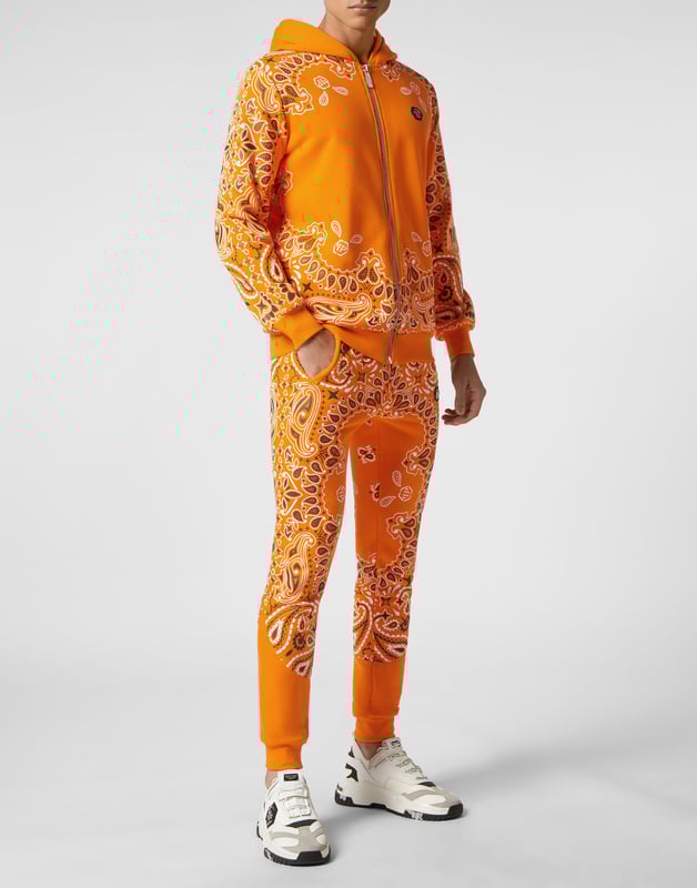 Für Ihren perfekten Laufstil haben wir diesen Trainingsanzug aus Baumwollfleece mit den kultigen Totenkopf- und Paisley-Dekoren entworfen.   Weiches Baumwollfleece im Bandanna-Stil mit Paisley-Print   Der ikonische strassbesetzte Skull-Print auf dem Rücken  PP-Sechseck auf einem Abzeichen aus Saffianleder auf Jacke und Hose   Kapuzenpulli mit Reißverschluss   Schlitztaschen   Bund mit Stopp-Kordelzug   Rippstrickbündchen "