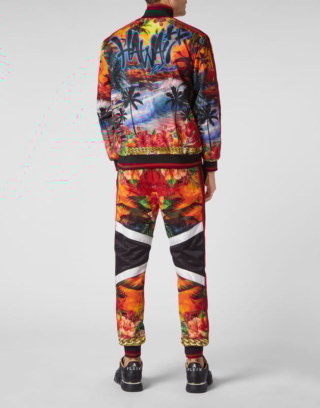 Choose to jog in style with the uniqueness identifying the style of Plein. We designed this techno fabric tracksuit featuring a Hawaii-themed print throughout.   Hawaii-inspired print triacetate   Contrasting sidebands on sleeves and outseam   Zip-up sweatjacket with PP Hexagon on a saffian leather patch sewn at left chest   Two slit pockets   PP Hexagon on a saffian leather badge sewn on the left side of pants   Slit pockets   Waistband with stop-cord drawstring   Rib knit hems